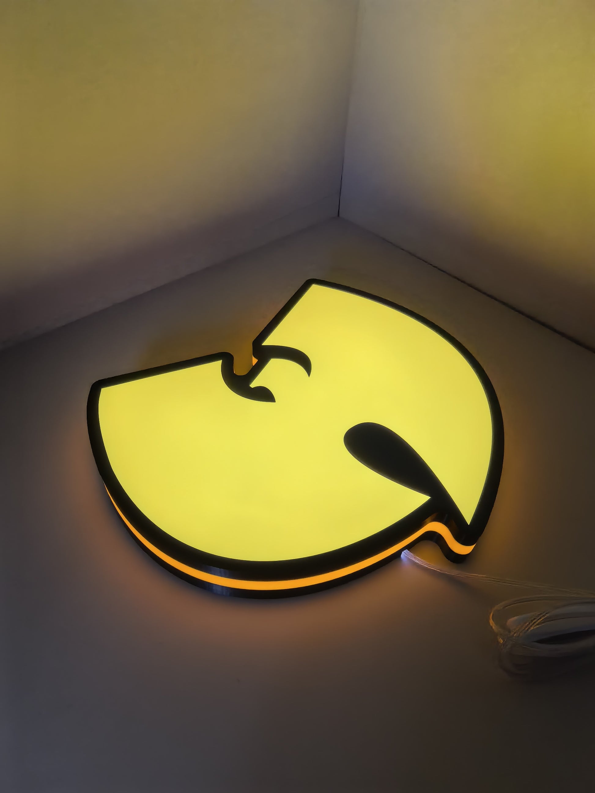 Illuminated flat lay angled view of Wu Tang Illuminated Sign in 40cm, unique wall art for desk and room decor