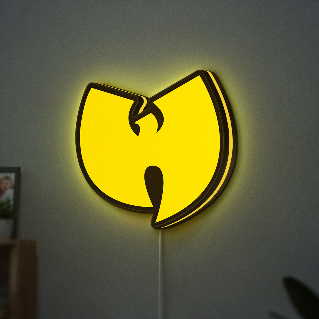 Wu Tang LED lightbox hanging on a wall with yellow glow