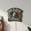 Unlit Bob Marley LED lightbox mounted on a wall in daylight