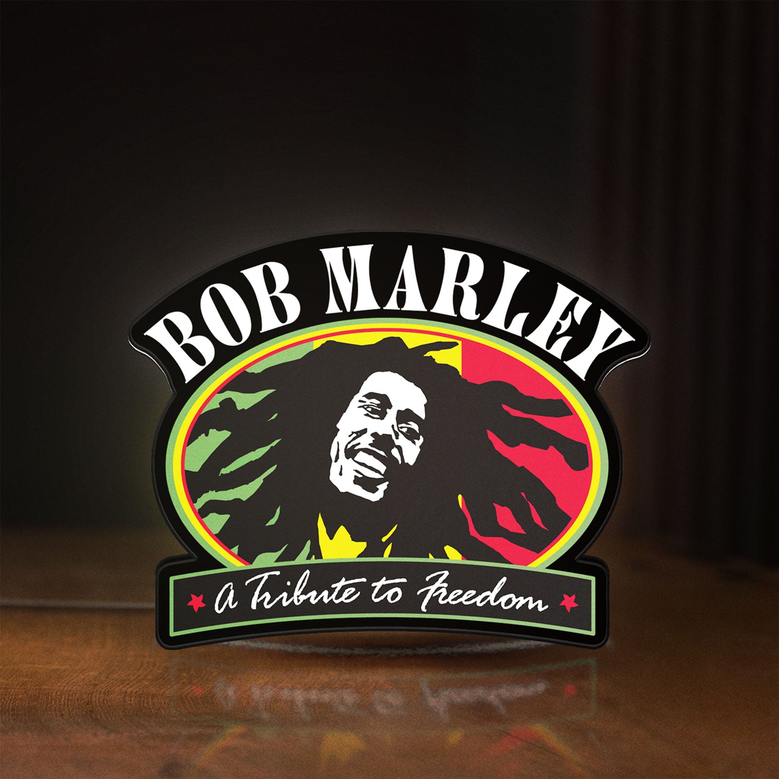 Front view of Bob Marley LED lightbox sign glowing on a wooden desk