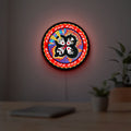 Kiss Rock And Roll Over LED lightbox hanging on a room wall with soft red light