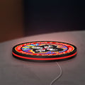 Kiss Rock And Roll Over LED lightbox lying flat on a desk with red glow