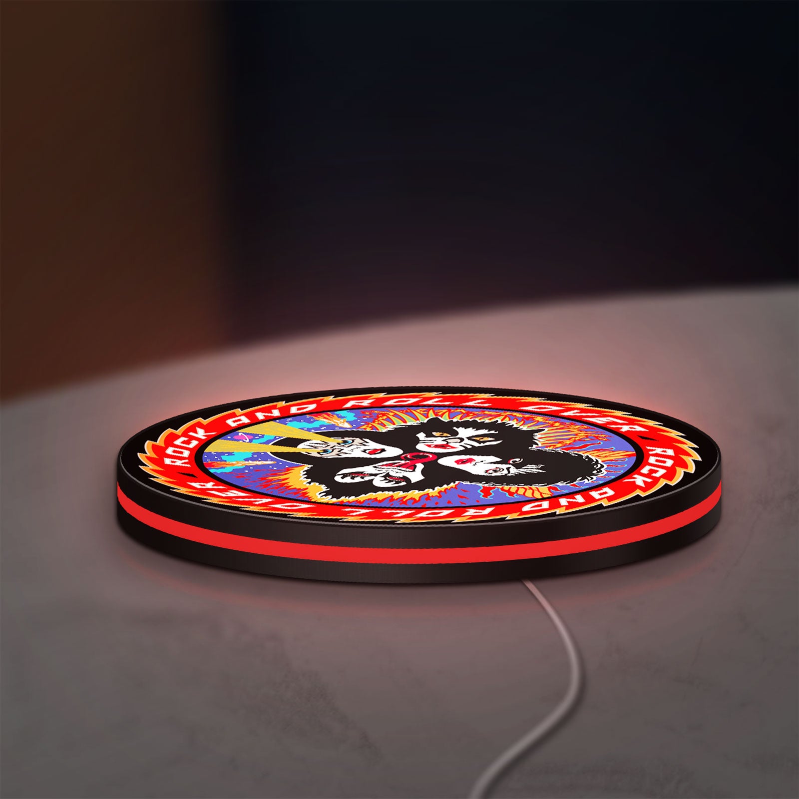 Kiss Rock And Roll Over LED lightbox lying flat on a desk with red glow