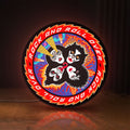 Front view of Kiss Rock And Roll Over LED lightbox sign glowing on a wooden desk