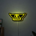 Aerosmith LED lightbox hanging on a wall with yellow glow