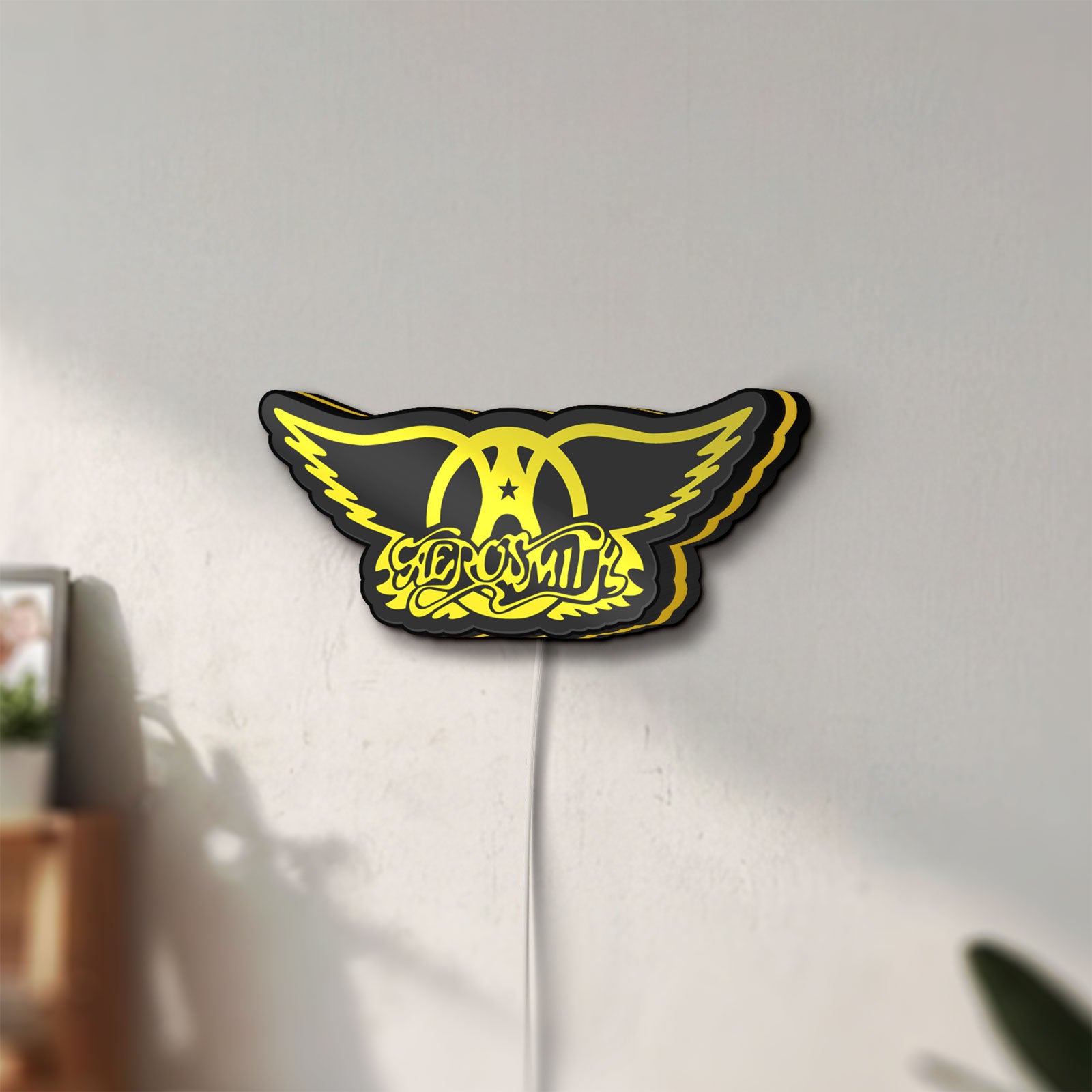 Unlit Aerosmith LED lightbox mounted on a wall in daylight