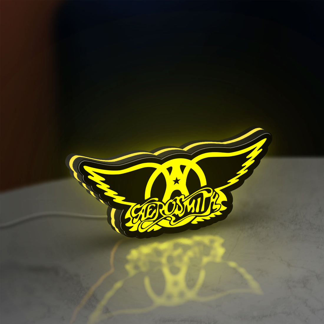 Aerosmith LED lightbox hanging on a wall with yellow glow