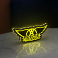 Aerosmith LED lightbox standing on a desk from an angled side view with yellow glow