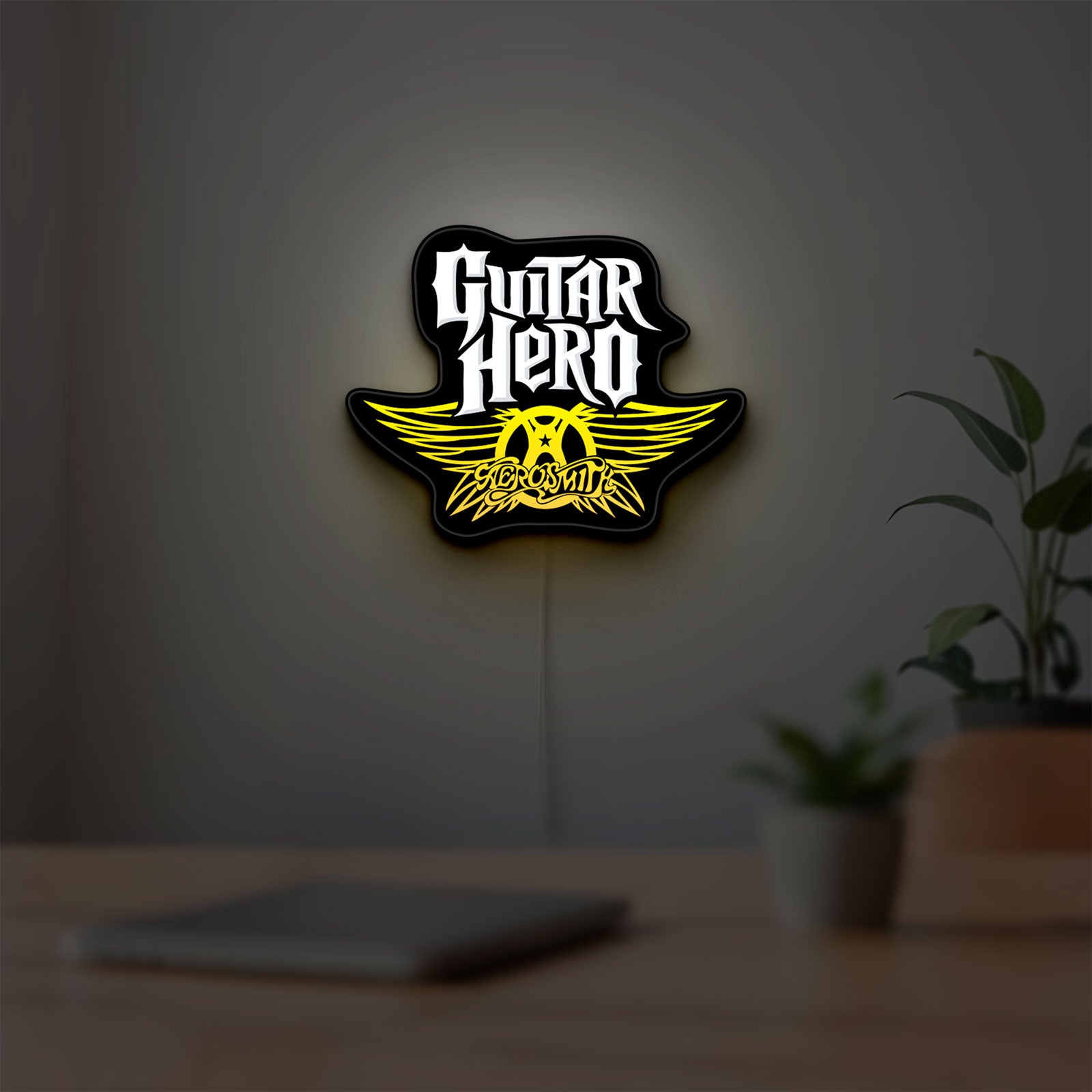 Aerosmith Guitar Hero LED lightbox hanging on a room wall with soft yellow light