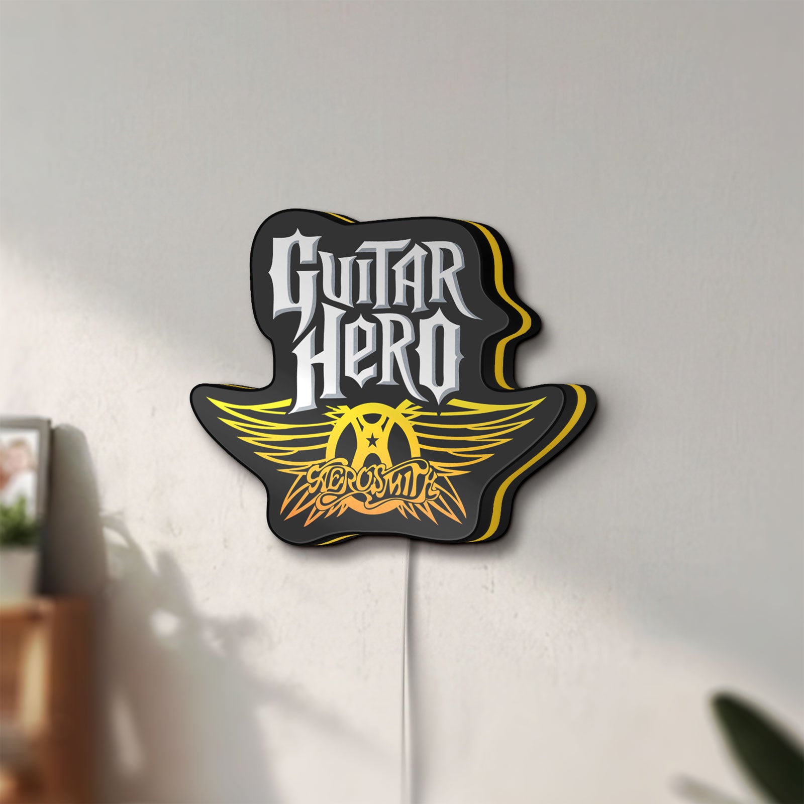 Unlit Aerosmith Guitar Hero LED lightbox mounted on a wall in daylight