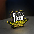 Aerosmith Guitar Hero LED lightbox standing on a desk from an angled side view with yellow glow