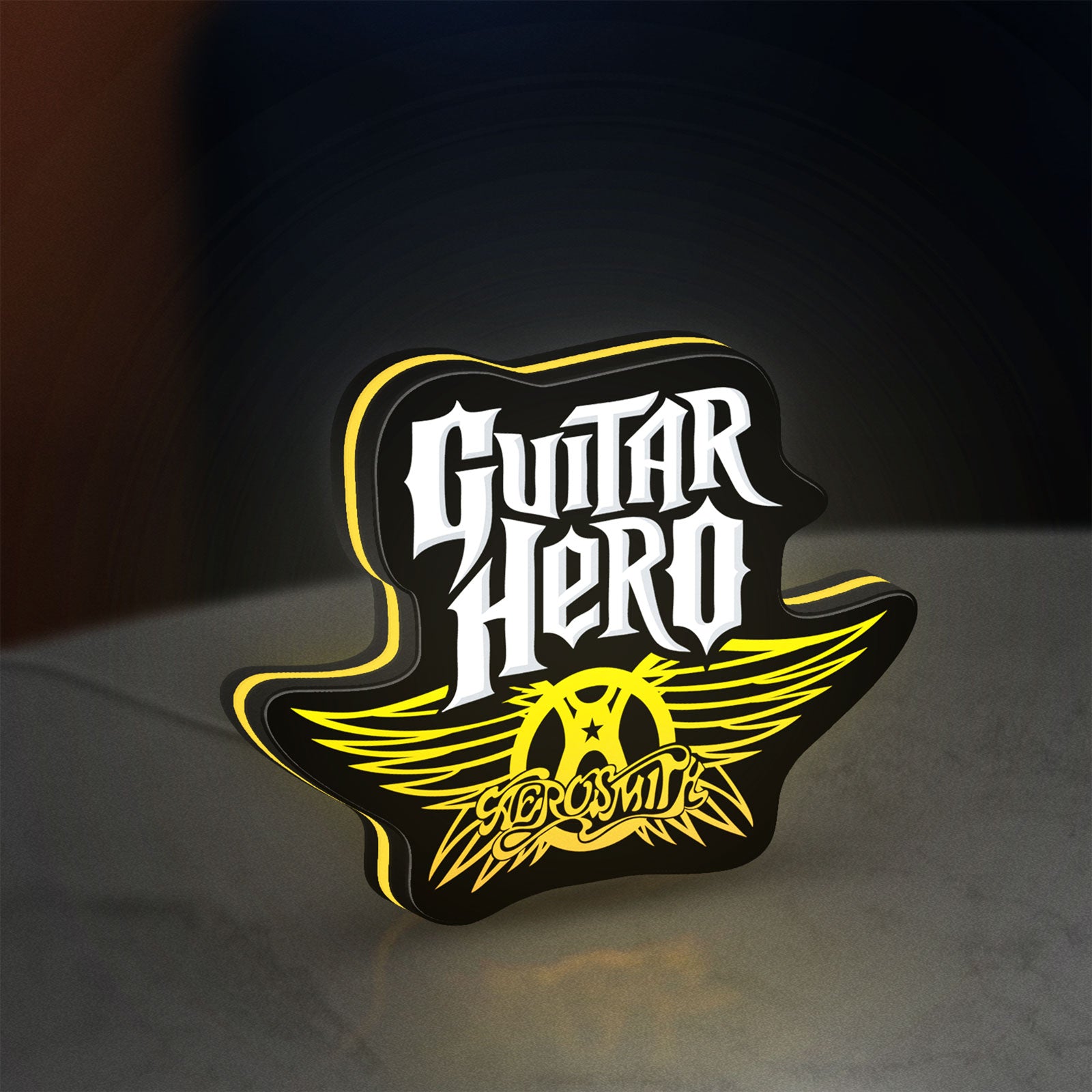 Aerosmith Guitar Hero LED lightbox standing on a desk from an angled side view with yellow glow