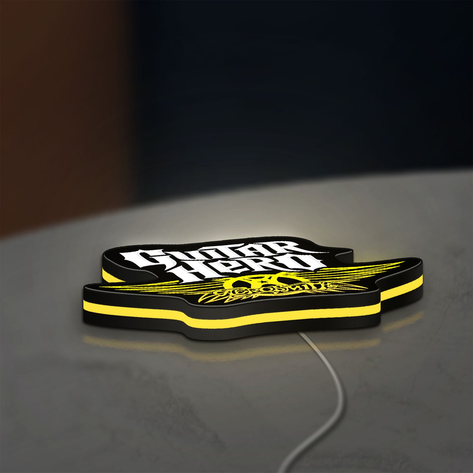 Aerosmith Guitar Hero LED lightbox lying flat on a desk with yellow glow