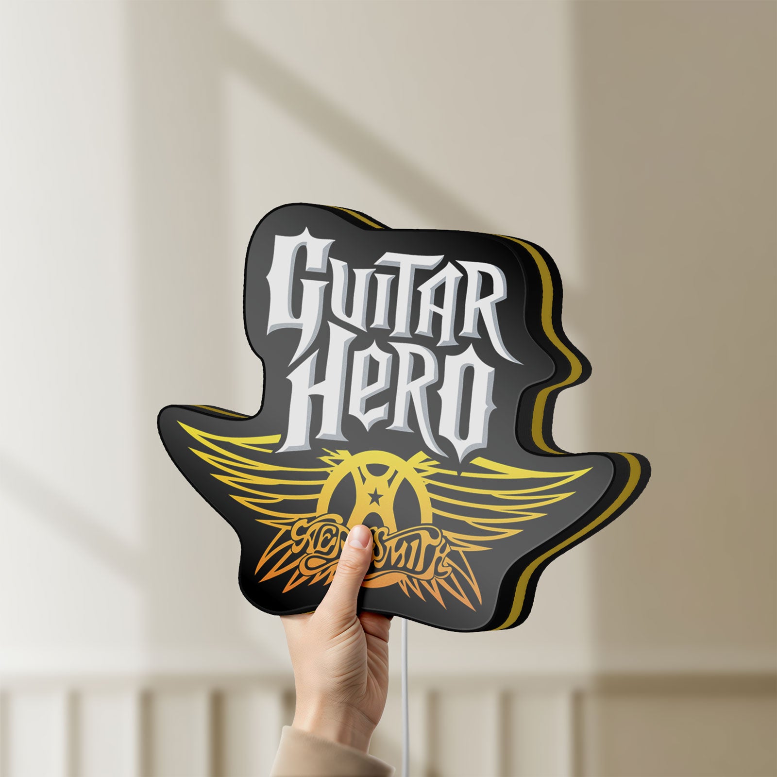 Unlit Aerosmith Guitar Hero LED lightbox held by hand to show size and details