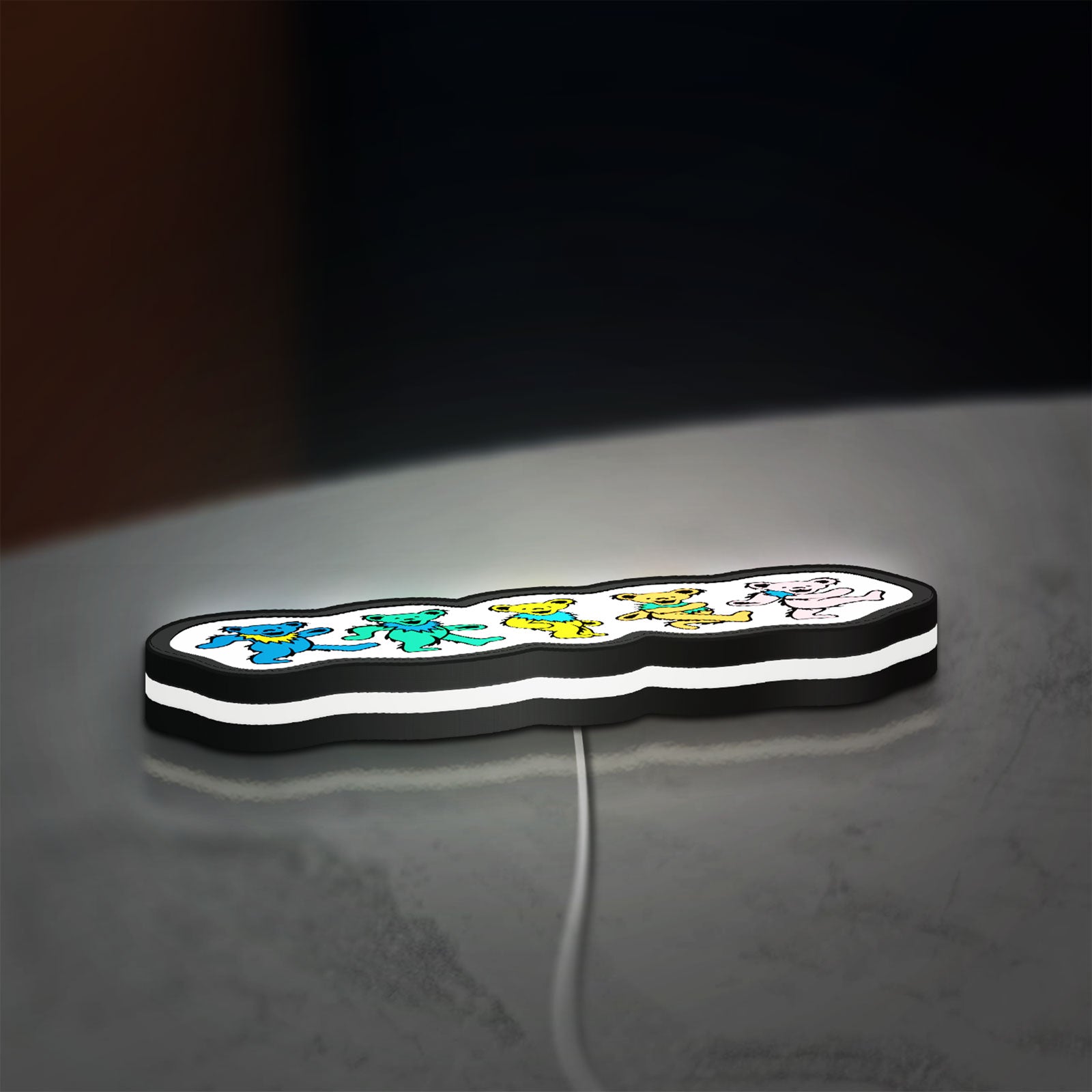 Grateful Dead Dancing Bears LED lightbox lying flat on a desk with white glow