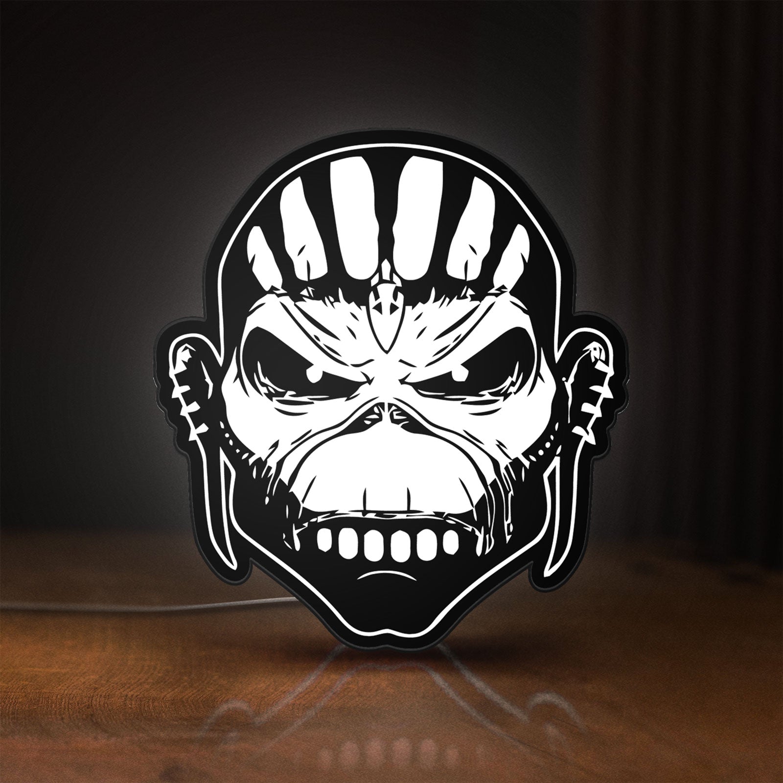 Front view of Iron Maiden The Book Of Souls LED lightbox sign glowing on a wooden desk