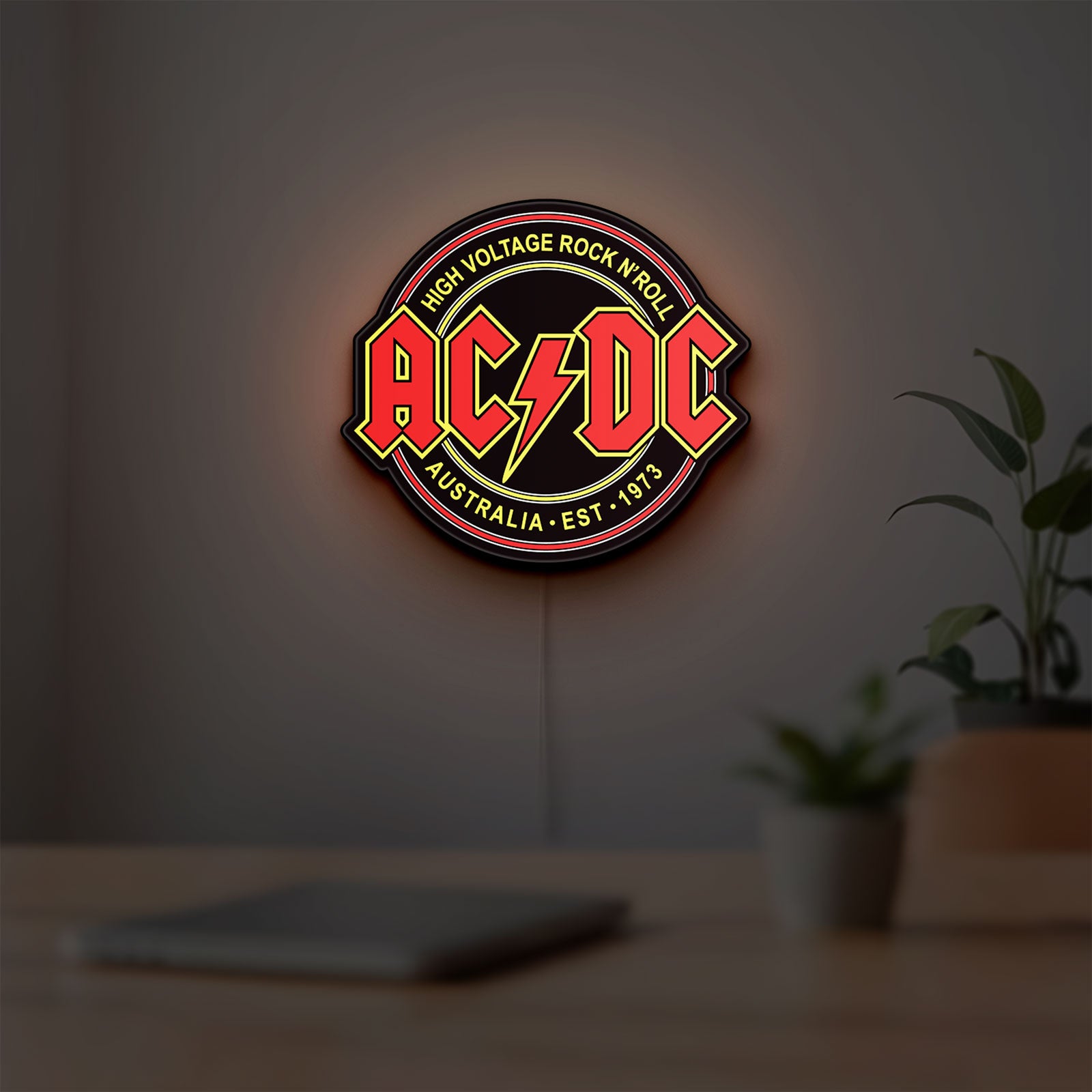 AC DC Rock N Roll LED lightbox hanging on a room wall with soft red light