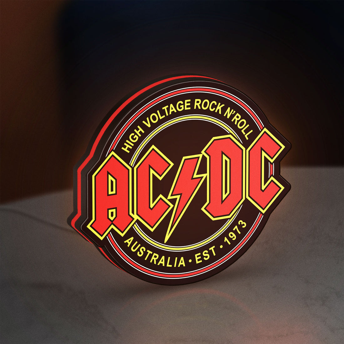 AC DC Rock N Roll LED lightbox hanging on a wall with red glow