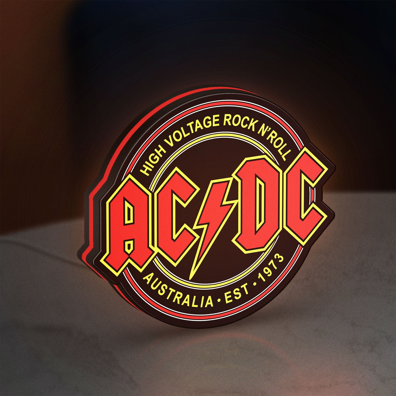 AC DC Rock N Roll LED lightbox standing on a desk from an angled side view with red glow
