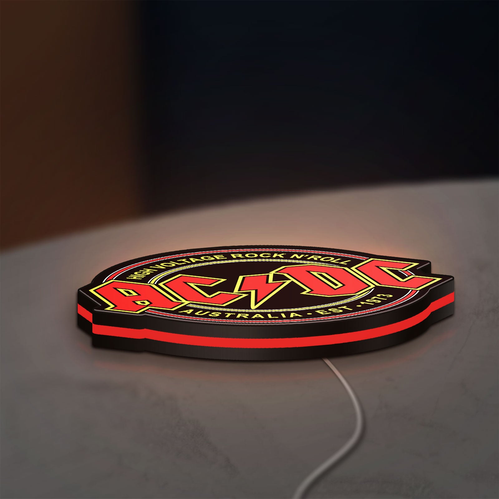 AC DC Rock N Roll LED lightbox lying flat on a desk with red glow
