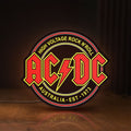Front view of AC DC Rock N Roll LED lightbox sign glowing on a wooden desk