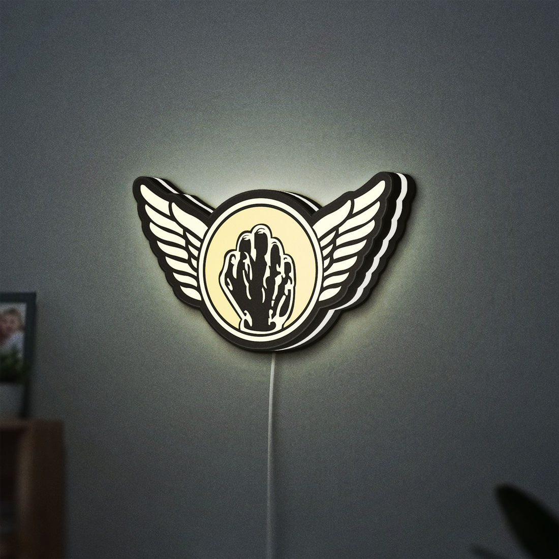 Kiss Army Fist LED lightbox hanging on a wall with white glow