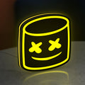 Marshmello LED lightbox standing on a desk from an angled side view with yellow glow