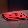 Have A Nice Day LED lightbox lying flat on a desk with red glow