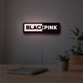 Blackpink LED lightbox hanging on a room wall with soft pink light