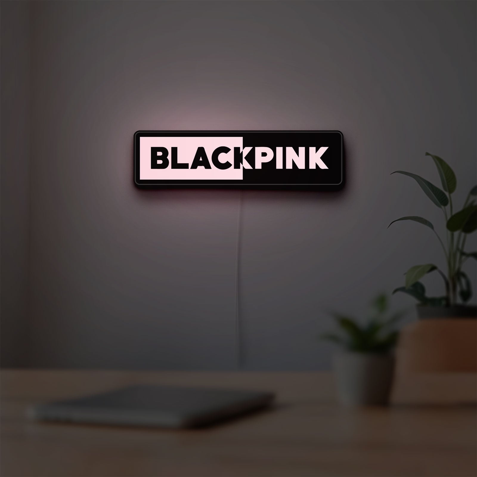 Blackpink LED lightbox hanging on a room wall with soft pink light