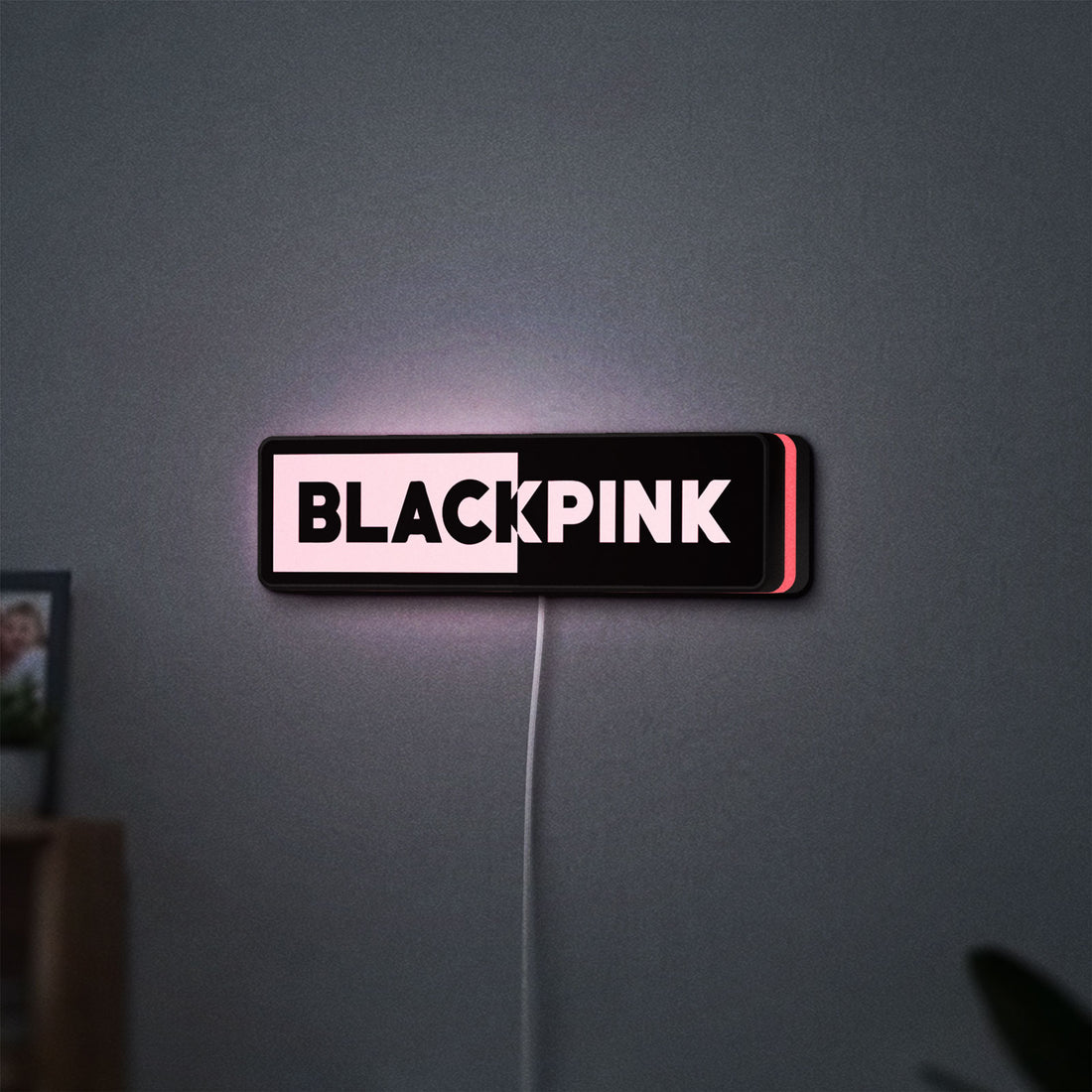 Blackpink LED lightbox hanging on a wall with pink glow