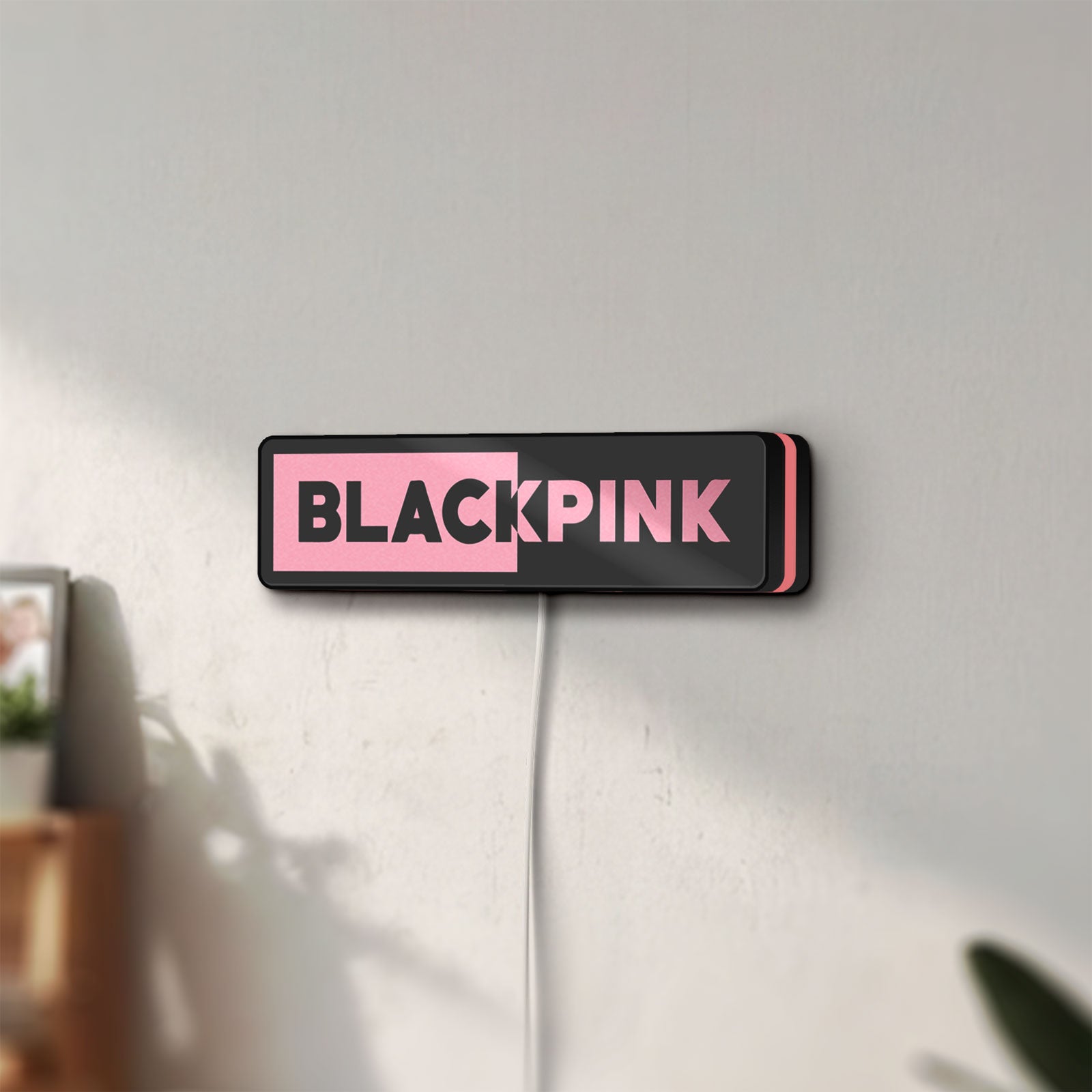 Unlit Blackpink LED lightbox mounted on a wall in daylight