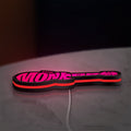 The Monkees Guitar LED lightbox lying flat on a desk with red glow