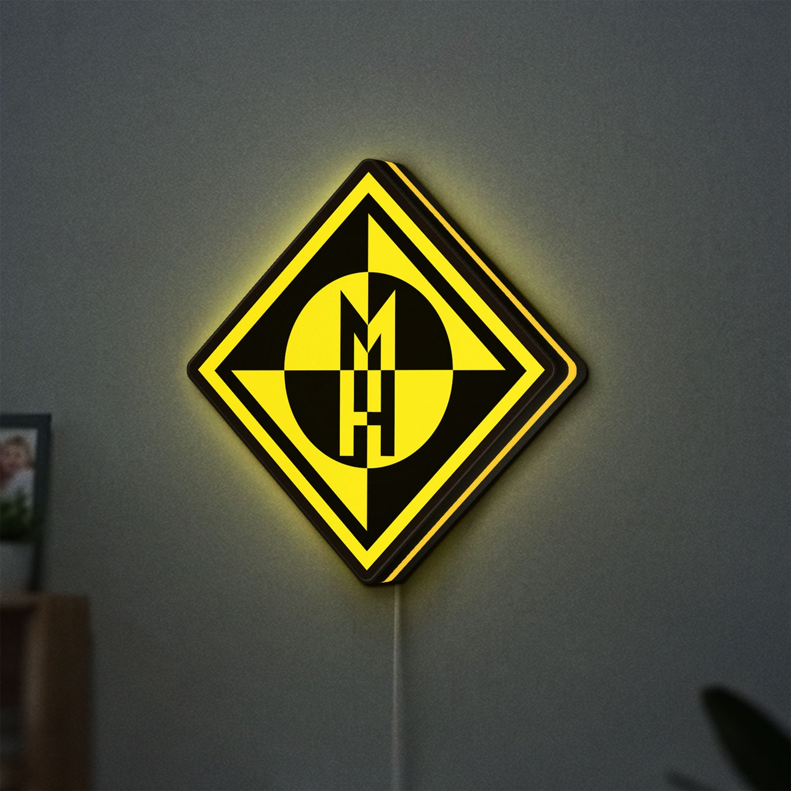 Machine Head LED lightbox hanging on a wall with yellow glow