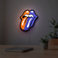 Rolling Stones LED lightbox hanging on a room wall with soft red light