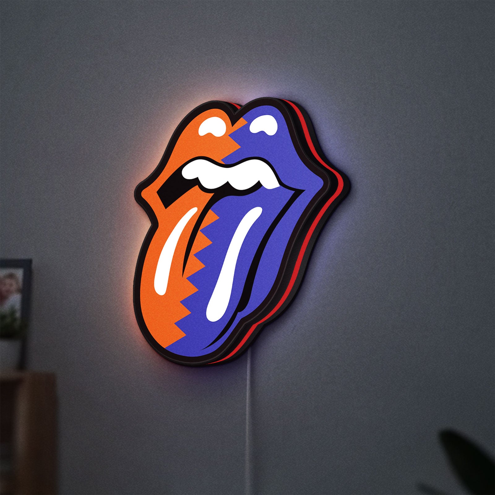 Rolling Stones LED lightbox hanging on a wall with red glow