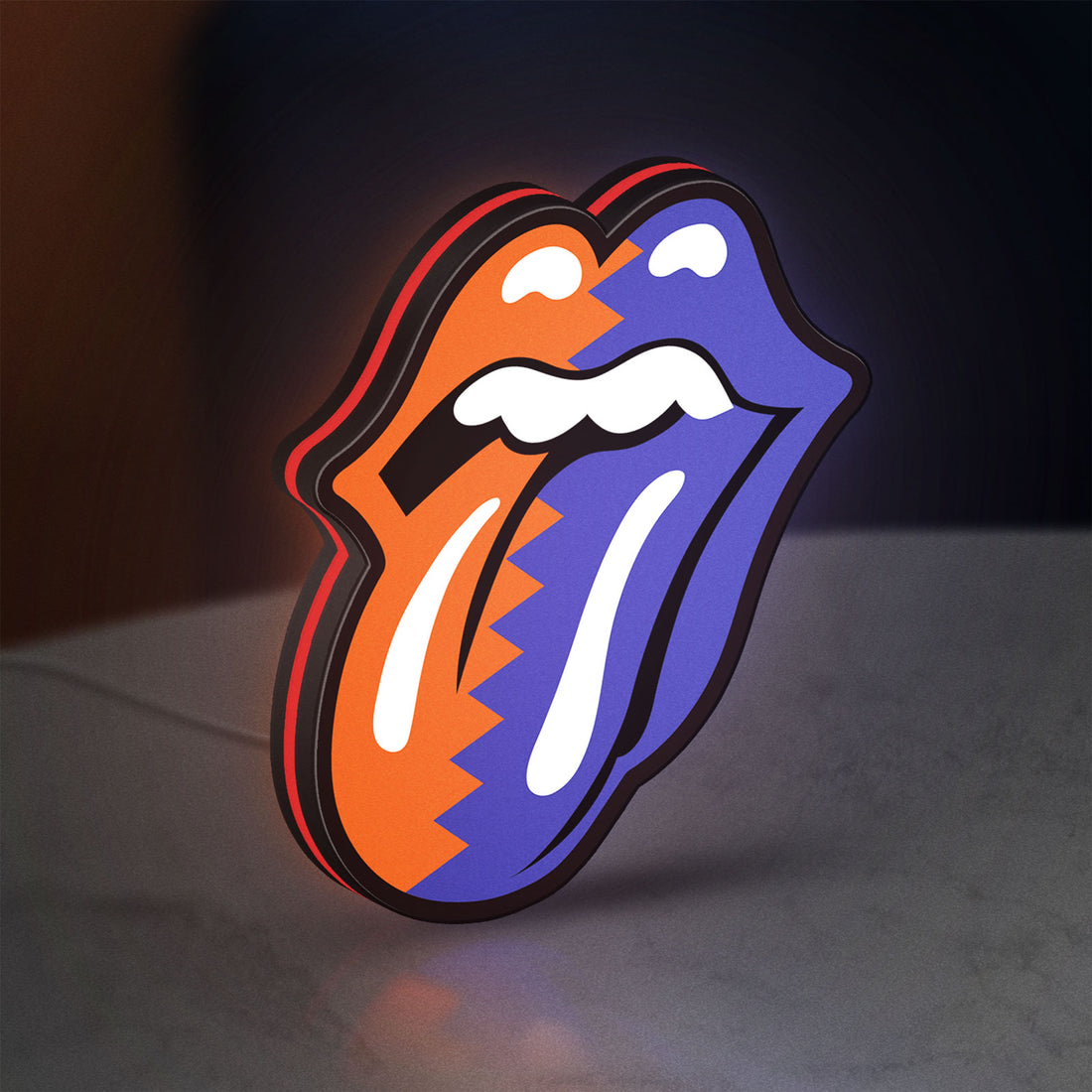 Rolling Stones LED lightbox hanging on a wall with red glow