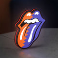 Rolling Stones LED lightbox standing on a desk from an angled side view with red glow