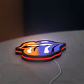 Rolling Stones LED lightbox lying flat on a desk with red glow