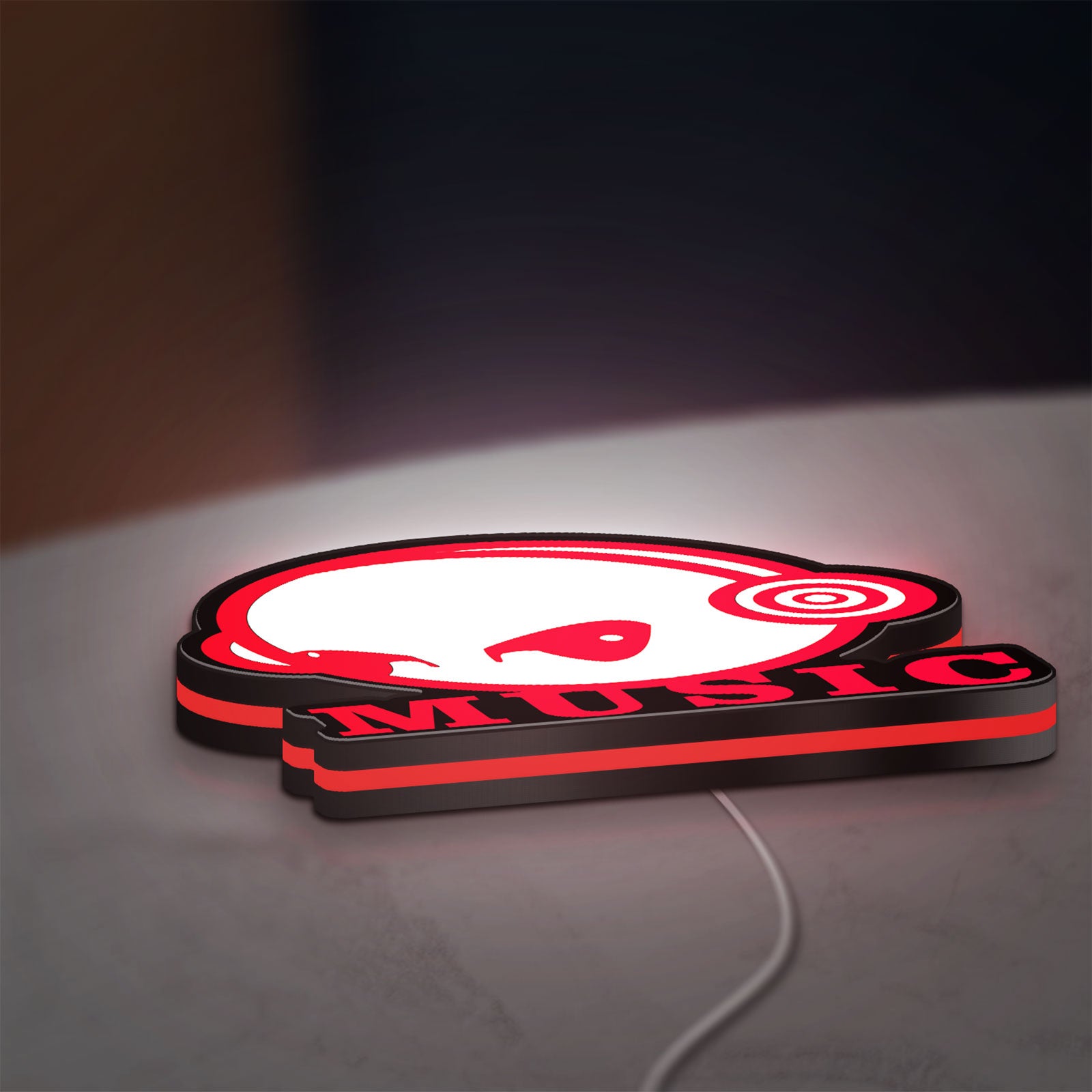 Custom Music LED lightbox lying flat on a desk with red glow