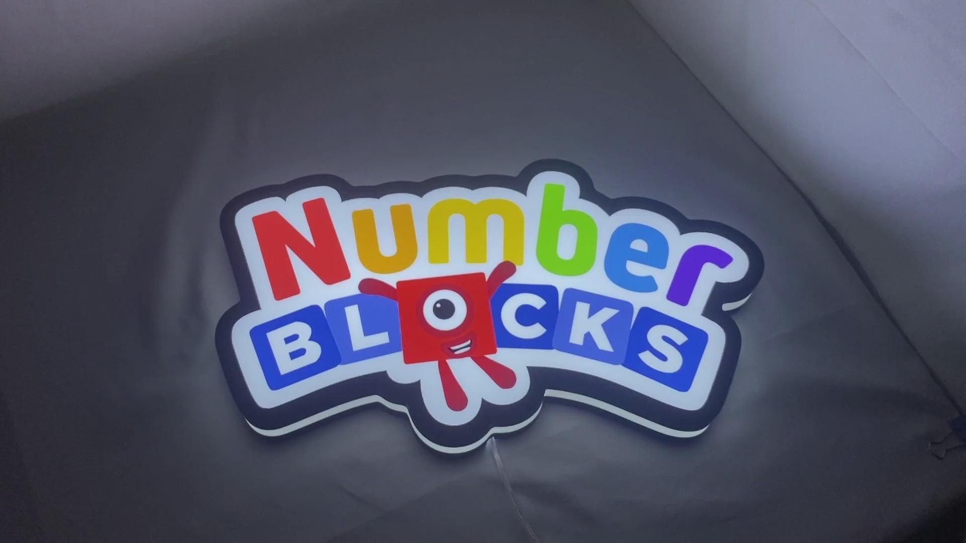 Product video showcase of Numberblocks 3D LED Sign, demonstrating unlit and illuminated lighting effects with a 360-degree rotating view, unique wall art for desk and room decor.