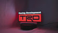 Product video showcase of Trd Racing Development 3D LED Sign, demonstrating unlit and illuminated lighting effects with a 360-degree rotating view, perfect for garage and man cave decor.