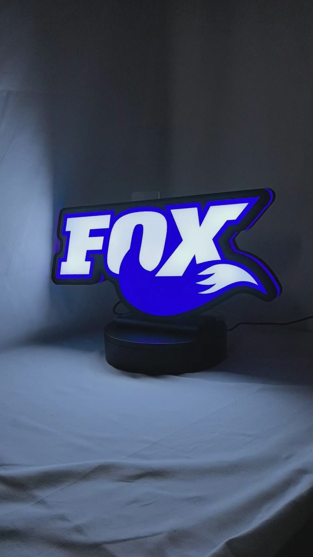 Product video showcase of Fox Racing Shox 3D LED Sign, demonstrating unlit and illuminated lighting effects with a 360-degree rotating view, perfect for garage and man cave decor.