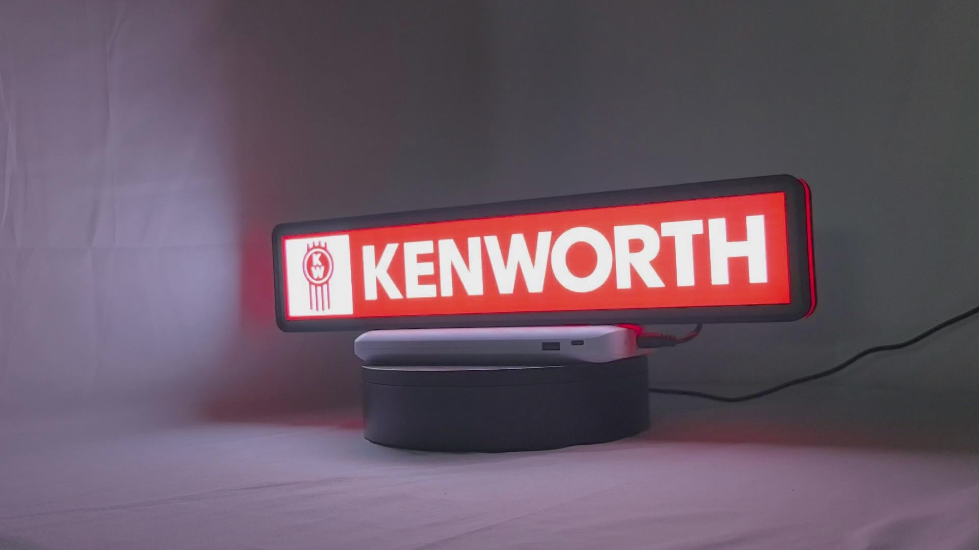 Product video showcase of Kenworth 3D LED Sign, demonstrating unlit and illuminated lighting effects with a 360-degree rotating view, perfect for garage and man cave decor.